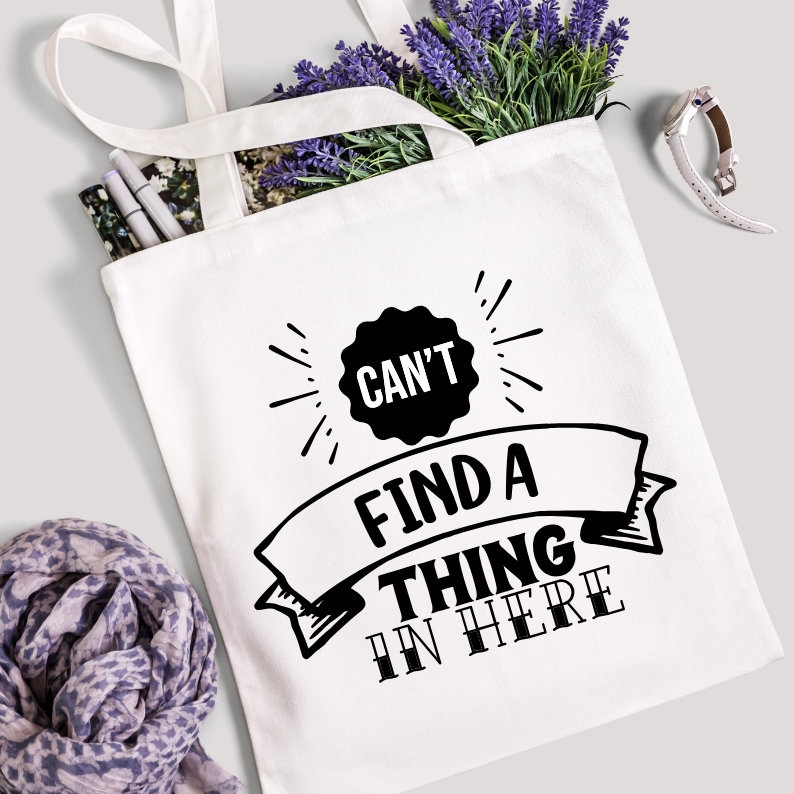 May include: White canvas tote bag with black text that reads "Can't find a thing in here".