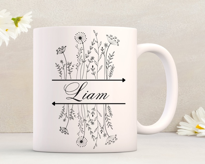 May include: White ceramic mug with a black floral design and the name "Liam" printed on the front.