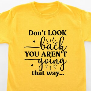 May include: Yellow t-shirt with black text that reads "Don't LOOK back YOU AREN'T going that way..."