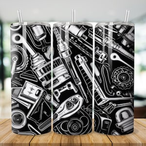May include: Three black and white stainless steel tumblers featuring a pattern of various car parts, including spanners, spark plugs, and gears.