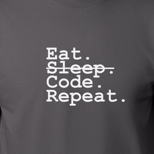 May include: A dark grey t-shirt with white text that reads "Eat. Sleep. Code. Repeat."