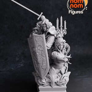 May include: A gray 3D printed figurine of a man and woman standing together. The man is holding a sword and shield, and the woman is holding a staff. The figurine is on a base with a candelabra and ornate details.