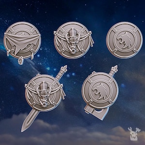 May include: Six different shield designs featuring a wolf head and a skull. The shields are made of a gray material and have a raised design. Some of the shields have a cloth wrapped around them.