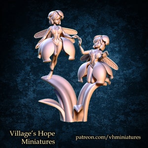May include: Two miniature fairies, sculpted in a light pink color, are perched on a flower stem. The fairies have delicate wings and are dressed in flower-shaped clothing. The flower stem is also sculpted in a light pink color and has leaves.