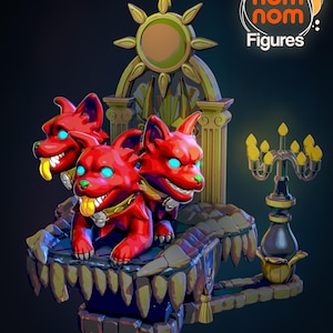 May include: A three-headed red dog figurine with glowing blue eyes sits on a throne with a golden sun design. The throne is decorated with gold accents and a stone base. A black candlestick with yellow candles sits on a stone platform to the right of the throne. The text "Nom Nom Figures" is visible in the upper right corner of the image.
