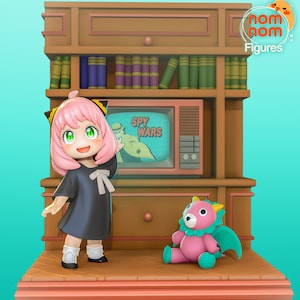 May include: A pink-haired anime girl in a black dress stands in front of a vintage television set playing "Spy Wars". A pink and teal dragon plush toy sits on the floor in front of her. The set is part of a wooden bookshelf with books on the top shelf.