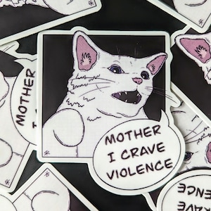 May include: A white cat with pink ears and a black background. The cat has a wide open mouth with sharp teeth and a surprised expression. The cat is in a comic book style frame with a speech bubble that says "Mother I crave violence".