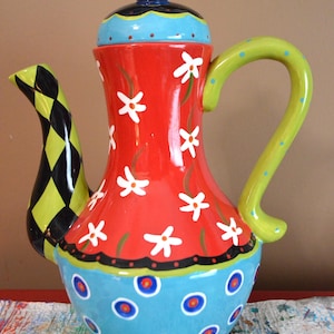 May include: A set of three ceramic canisters with lids. The canisters are white with a blue floral pattern. The largest canister is 8 inches tall, the medium is 7 inches, and the smallest is 6 inches.