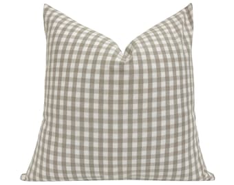 May include: A beige and white gingham pillow with a square pattern. The pillow is made of a soft, woven fabric.