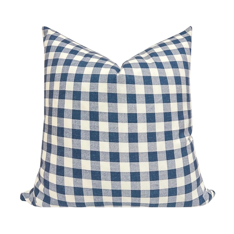 May include: A square pillow with a blue and white checkered pattern. The pillow has a classic gingham design, with a soft, textured appearance. The pillow is a decorative item for a bed or sofa.