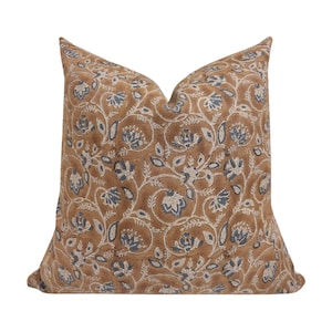 May include: A brown and blue floral patterned throw pillow with a square shape.
