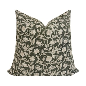 May include: A green throw pillow with a white floral pattern. The pillow is made of a soft, comfortable fabric and is perfect for adding a touch of elegance to any room.