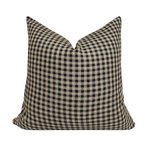 K&ouml;nnte beinhalten: Schwarzes und braunes Gingham-Kissenbezug. Der Kissenbezug ist aus weichem, gewebtem Stoff mit einem karierten Muster.