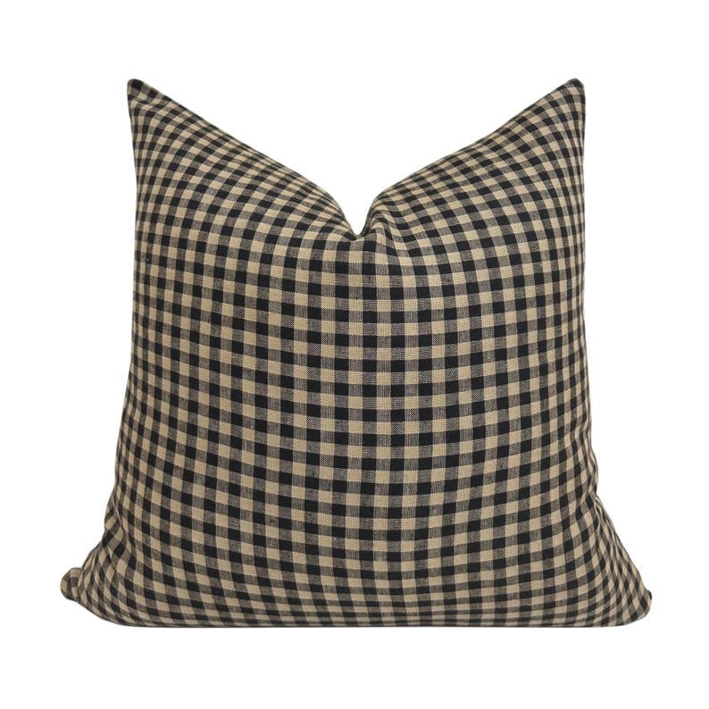 K&ouml;nnte beinhalten: Schwarzes und braunes Gingham-Kissenbezug. Der Kissenbezug ist aus weichem, gewebtem Stoff mit einem karierten Muster.