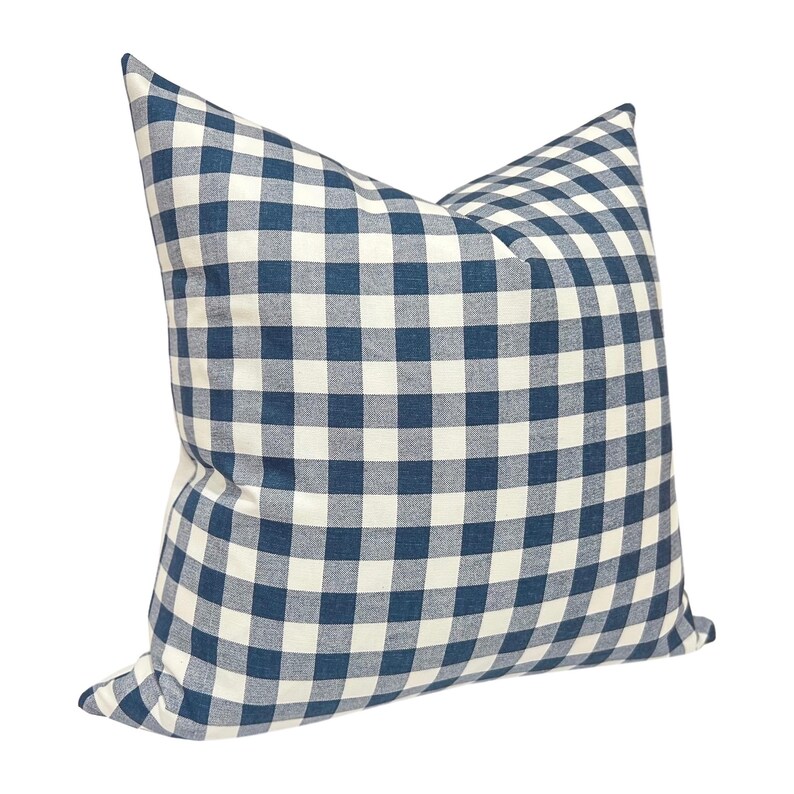 May include: A square pillow with a blue and white checkered pattern. The pillow has a classic gingham design, with a soft, textured appearance. The pillow is a decorative item for a bed or sofa.