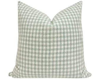 May include: A green and white gingham pillow cover. The pillow cover is made of a soft, woven fabric with a subtle texture.