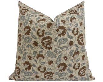 May include: Square decorative pillow with a floral pattern. The pillow features a beige background with brown and gray floral designs. The pillow is a square shape and is likely used for home decor.