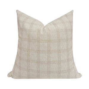 May include: A beige throw pillow with a subtle brown plaid pattern. The pillow is made of a soft, textured fabric.