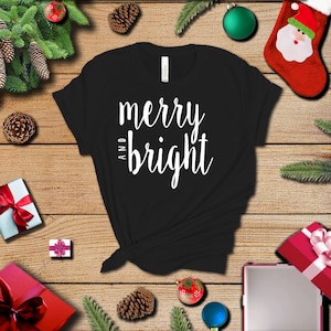 May include: Black t-shirt with white text that reads "merry and bright".