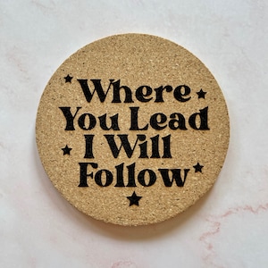 K&ouml;nnte beinhalten: Ein Korkuntersetzer mit dem Text "*Where You Lead I Will Follow*" in schwarzer Schrift.
