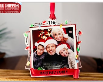 Könnte beinhalten: Ein roter und weißer Weihnachtsbaumschmuck mit einem Familienfoto, einem roten Band und dem Text "The Martinez Family". Der Schmuck hat einen klaren Plastikrahmen mit einer Lichterkette um den Rand.