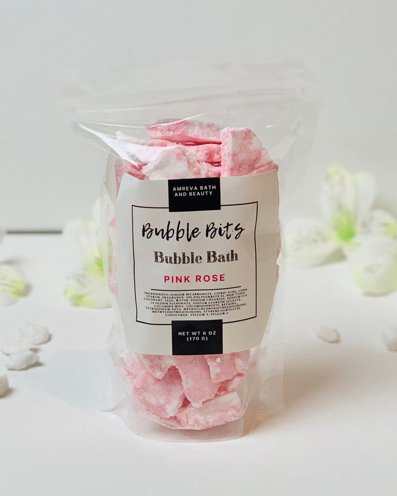 May include: A clear plastic bag filled with pink and white bubble bath bits. The label reads "Bubble Bits Bubble Bath Pink Rose" and "Net Wt 6 oz (170 g)".
