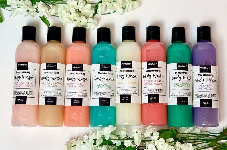 May include: Eight clear plastic bottles of moisturizing body wash with black lids and white labels. The labels have the text "Moisturizing Body Wash" and the scent of each body wash. The scents are: White Water - Passion Fruit, Vanilla & Coconut Cream, Tropical Fruit - Sugar Cane, Coconut - Key Lime, Milk & Honey, Raspberry - White Musk, Cucumber - Watermelon, Lavender - Oatmilk.