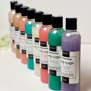 May include: Eight bottles of moisturizing body wash in various colors and scents. The bottles are labeled with the scents: Strawberry & White Musk, Cucumber & Watermelon, Lavender & Oatmilk.