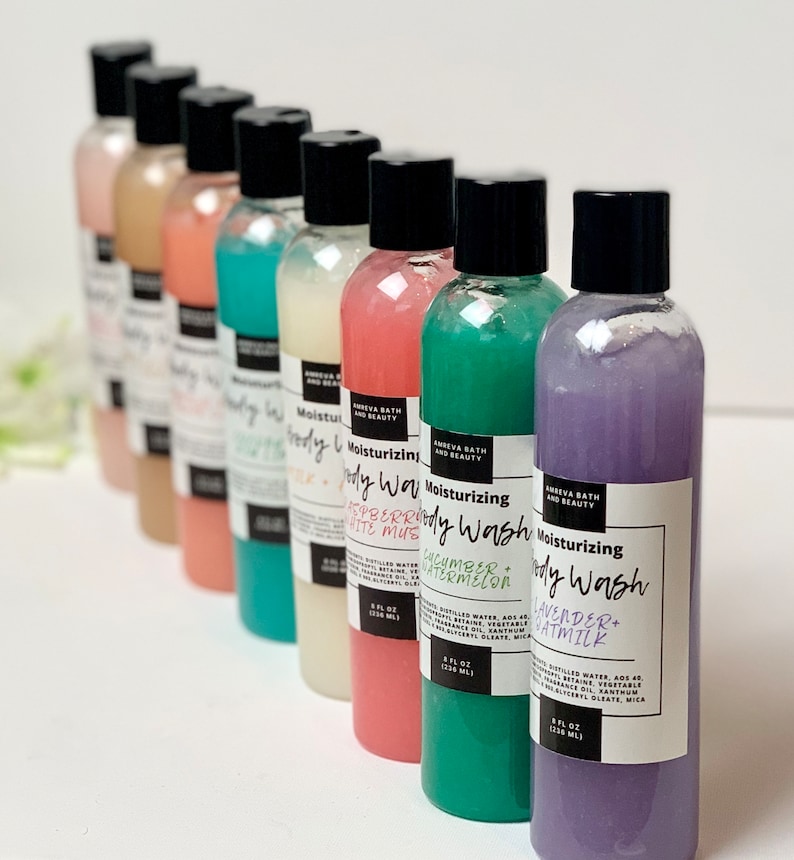 May include: Eight bottles of moisturizing body wash in various colors and scents. The bottles are labeled with the scents: Strawberry & White Musk, Cucumber & Watermelon, Lavender & Oatmilk.