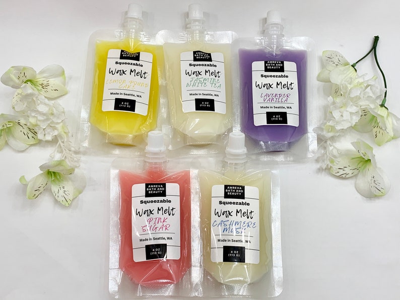 May include: An assortment of squeeze pouches filled with scented wax melts. The pouches are labeled with various scents, including Lemon Pound Cake, Jasmine White Tea, Lavender Vanilla, Pink Sugar, and Cashmere Mist. Each pouch contains 4 oz (113 g) of wax.
