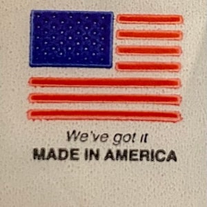 May include: A white label with a red, white and blue American flag graphic. The text "We've got it MADE IN AMERICA" is printed below the flag.