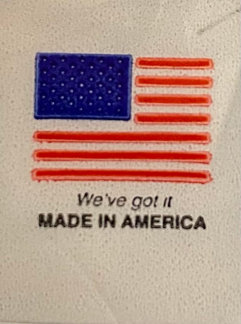 May include: A white label with a red, white and blue American flag graphic. The text "We've got it MADE IN AMERICA" is printed below the flag.