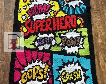 May include: A colorful crochet blanket with a superhero theme. The blanket features various comic book speech bubbles with words like "POW!" and "BOOM!" The blanket is black with bright colors like red, yellow, blue, green, and pink.
