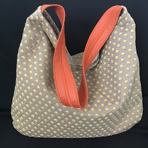 Große „Hobo“-Handtasche aus beigem und orangefarbenem Jacquard-Stoff mit Rautenmuster