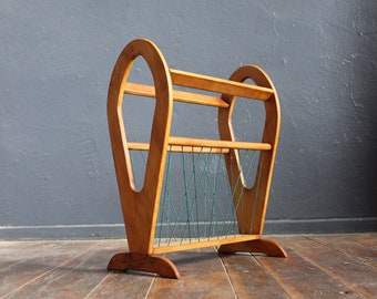 Vintage magazine rack made of light wood with green braided cord