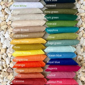May include: A color chart labeled Omeely Natural 100% Linen 200gsm displaying fabric swatches in various shades including black, brown, grey, white, ivory, sand, cream, yellow, orange, red, green, blue, pink, and purple with printed color names.