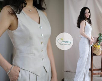 May include: A sleeveless beige vest with a V-neckline and five round buttons down the front, paired with matching high-waisted wide-leg trousers. The set features a textured fabric and includes a logo with the text Omeely Couture Oatmeal Happy.