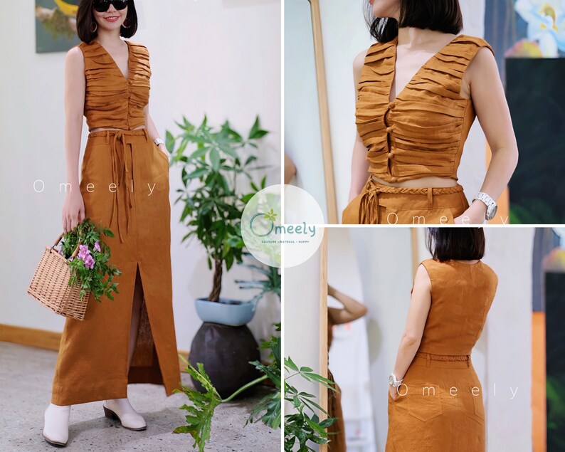Peut inclure: Un ensemble deux pi&egrave;ces de couleur marron chaud compos&eacute; d'un haut court sans manches fronc&eacute; avec un d&eacute;collet&eacute; en V et une fermeture boutonn&eacute;e, associ&eacute; &agrave; une jupe longue taille haute avec une fente avant, une ceinture tress&eacute;e et des poches.