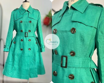May include: A bright green double-breasted trench coat featuring a classic collar, shoulder epaulets, and a matching waist belt with a rectangular buckle. The coat has dark brown buttons and long sleeves with buckled cuffs. The logo Omeely is visible.