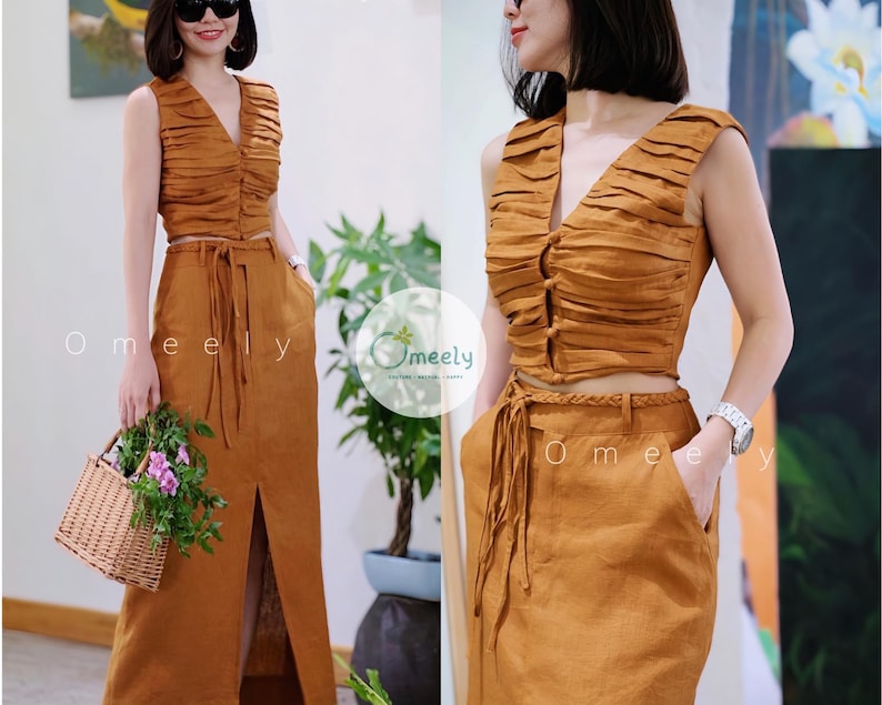 Peut inclure: Un ensemble deux pi&egrave;ces de couleur brun moutarde compos&eacute; d'un haut court sans manches &agrave; col en V avec des d&eacute;tails pliss&eacute;s horizontaux et des boutons sur le devant, assorti d'une jupe longue taille haute avec une fente et une ceinture tress&eacute;e.