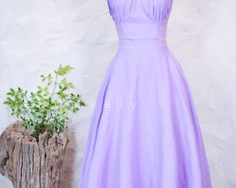 May include: A two-piece lavender dress set featuring a sleeveless crop top with a gathered, pleated bodice and thin spaghetti straps, paired with a matching high-waisted, floor-length A-line skirt that flows into a full, voluminous silhouette.