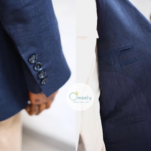 Op de afbeelding: Een donkerblauwe blazer van gestructureerde stof met vier knopen op de mouwmanchet en een binnenvoering met twee paspelzakken. Het logo Omeely is in het midden zichtbaar. Het kledingstuk wordt getoond op een houten paspop.