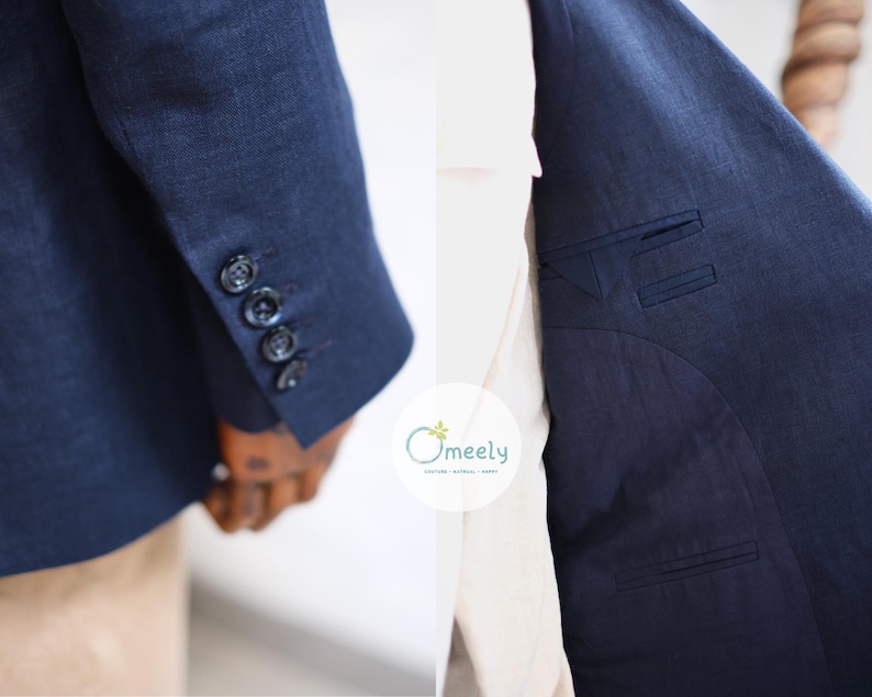Op de afbeelding: Een donkerblauwe blazer van gestructureerde stof met vier knopen op de mouwmanchet en een binnenvoering met twee paspelzakken. Het logo Omeely is in het midden zichtbaar. Het kledingstuk wordt getoond op een houten paspop.