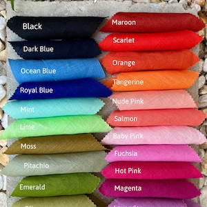 May include: A color chart of linen fabric swatches in various shades, including black, blue, orange, pink, and green. The text "Omeely Natural" is at the top, with "100% Linen 150gsm" at the bottom. The swatches are arranged on a stone surface.