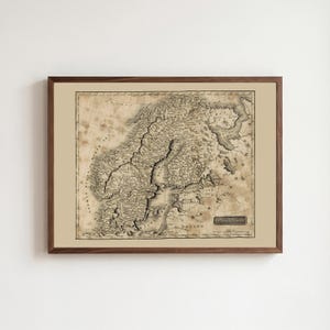 May include: A framed antique-style map of Scandinavia and the Baltic region in sepia tones. The map features detailed topography, coastlines, and historical labels including Sweden, Norway, and Poland. It is enclosed in a dark brown wooden frame.