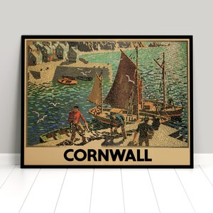 May include: A vintage travel poster featuring a colorful illustration of a harbor scene in Cornwall, England. The poster depicts a small fishing village with boats and people on the water. The text "CORNWALL" is printed in bold black letters at the bottom of the poster.