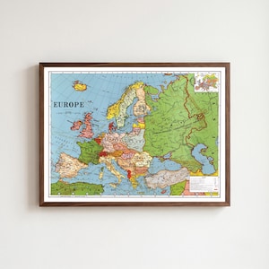Op de afbeelding: Een politieke kaart van Europa in vintage-stijl, ingelijst in donker hout. De kaart toont gekleurde grenzen voor verschillende landen, waaronder de Russische Socialistische Federatieve Sovjetrepubliek, met tekstlabels en een legenda.
