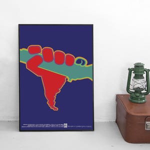 Pode incluir: Um cartaz retangular numa moldura preta com um punho vermelho estilizado a agarrar uma barra horizontal verde sobre um mapa vermelho da América do Sul, num fundo azul escuro com pequeno texto branco na parte inferior.