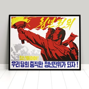 Könnte beinhalten: Ein Vintage-Propagandaposter mit rotem Hintergrund und einer gelben und roten Fackel. Zwei Figuren halten die Fackel und einen Hammer. Der Text in Koreanisch lautet "Lasst uns die Avantgarde werden!" und "Die glorreiche Avantgarde unserer Partei!"