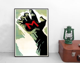 May include: A framed poster featuring a stylized black silhouette of a hand reaching upward against a pale green and white background. A bold, red letter M is centered on the palm of the hand. The artwork uses sharp, angular lines and high contrast.
